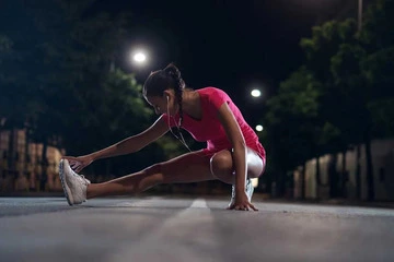 Mujer haciendo ejercicio por la noche en la calle con Oscar Rodenas entrenador personal online